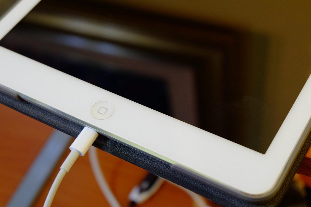 close-up of an iPad with a charging cable connected to the port
